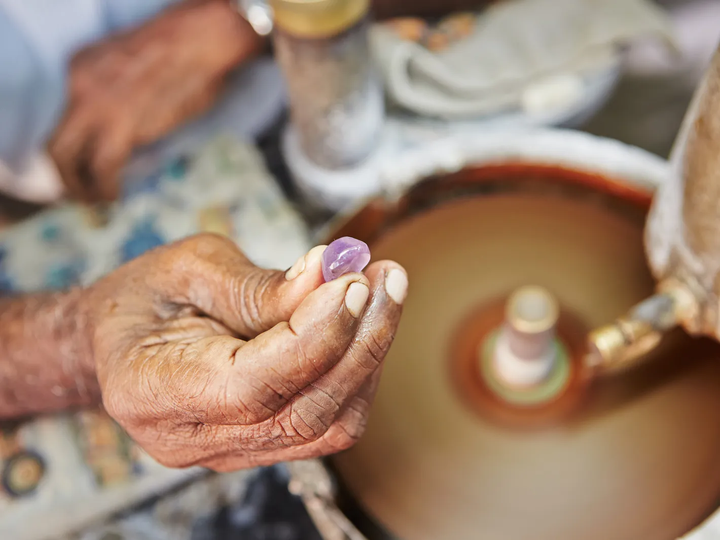 The stone held to the turning wheel, one facet at a time, checked and returned to the lap.