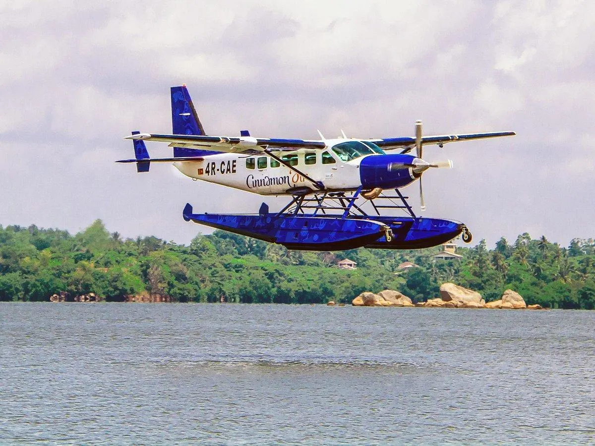 A landing on water — a jungle reservoir, a lagoon, a lake in the tea hills — stepping from the cabin onto a jetty where the road would take half a day.